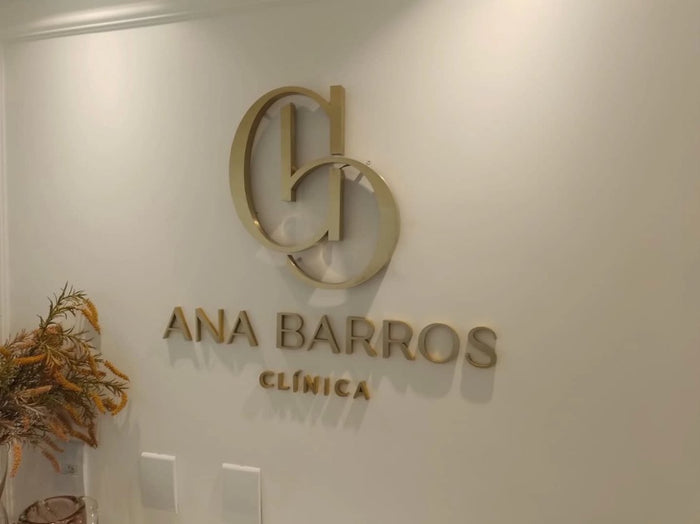 Ana Barros Clínica: Marca em latão dourado com letras em acrílico com face em latão.