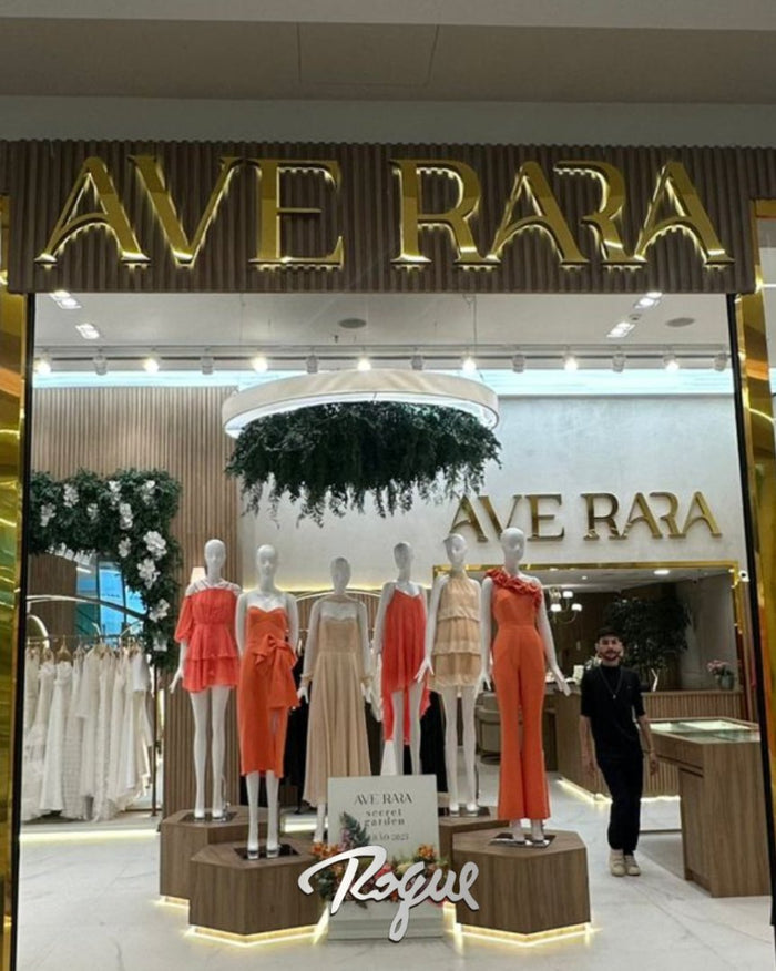 Ave Rara: Fachada de loja com letreiro em latão dourado e iluminação em LED.