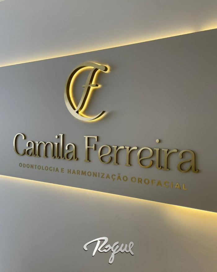 Camila Ferreira Odontologia: Letras em acrílico com face em latão dourado escovado e marca com LED interno em efeito sanca.
