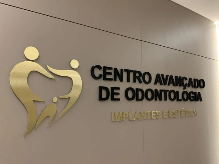 Centro Avançado de Odontologia: Acrílico preto combinado com acrílico com face em latão dourado.