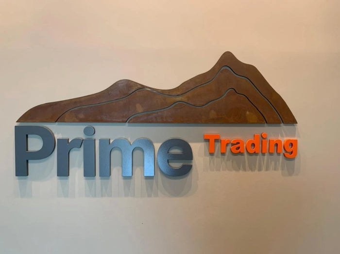 Prime Trading: Marca em aço corten com letras em alto relevo pintadas.